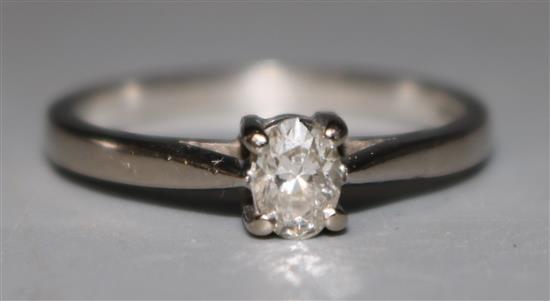 A modern 18ct white gold and oval cut solitaire diamond ring, size Q.